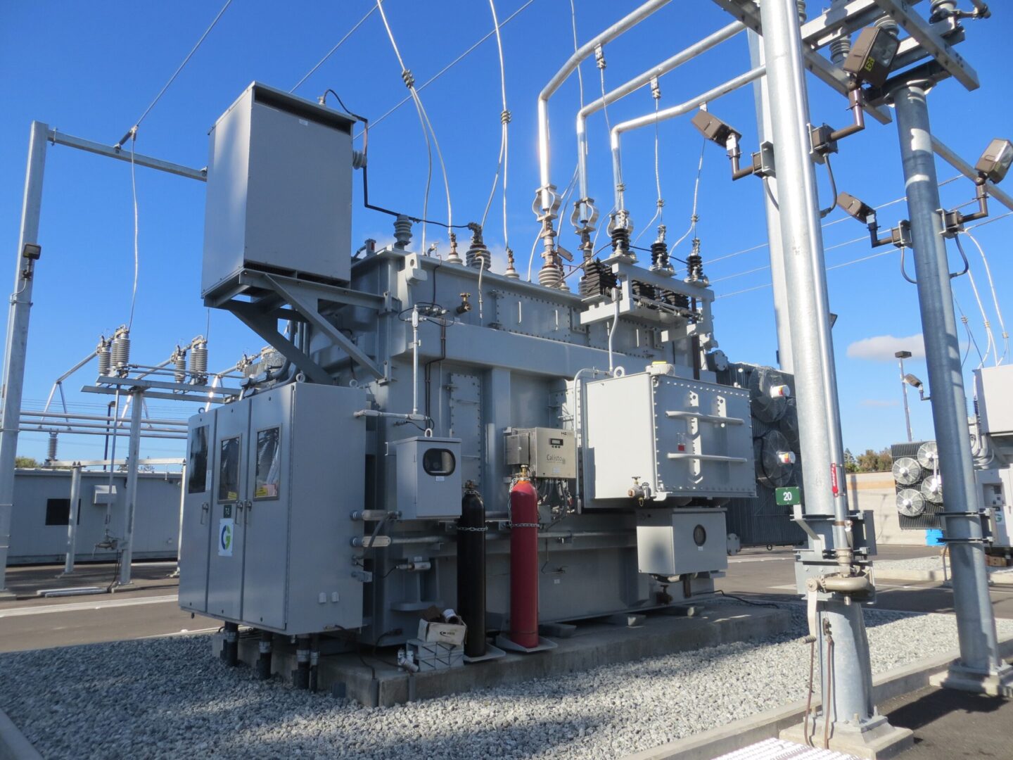 A large electrical power transformer on top of gravel.